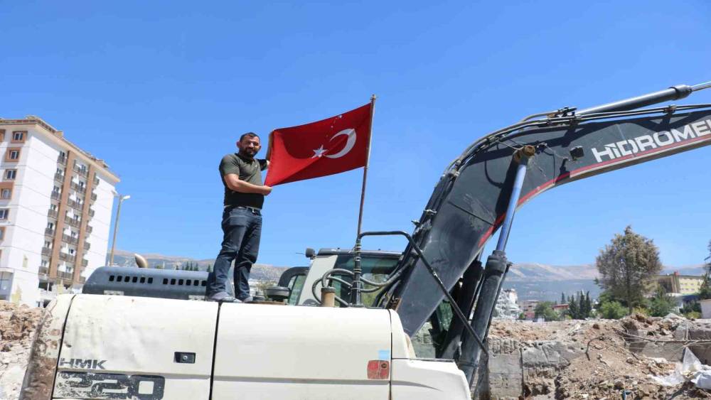 ENKAZDAN ÇIKARDIĞI TÜRK BAYRAĞINI İŞ MAKİNESİNDE DALGALANDIRIYOR